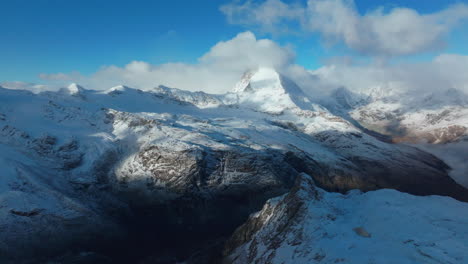 First-fresh-snowfall-dusting-early-morning-cloudy-Matterhorn-Zermatt-Glacier-peak-landscape-scenery-aerial-drone-autumn-Swiss-Alps-top-of-summit-Gornergrat-Railway-Switzerland-forward-reveal-motion