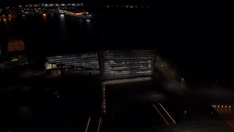 Harpa-Concert-Hall-and-Conference-Centre-in-Reykjavik-at-night,-drone