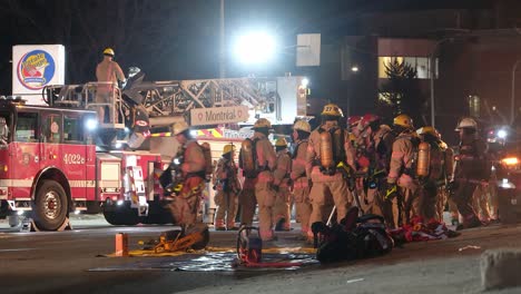 Feuerwehrleute-Arbeiten-Zusammen,-Um-Rettungsausrüstung-Während-Eines-Brandes-In-Montreal,-Quebec,-Kanada-Vorzubereiten