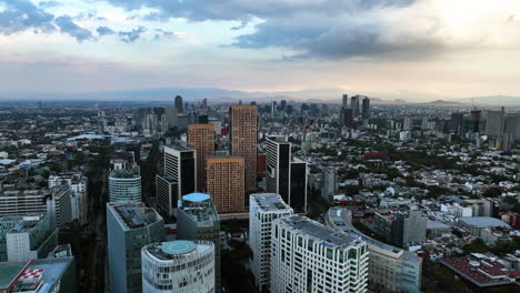 Drone-orbiting-the-Miyana-Complex,-moody-sunset-in-Polanco,-Mexico-city