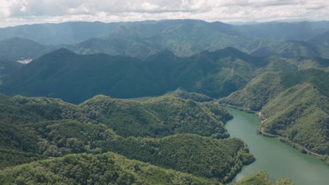 Aerial-panoramic-drone-above-Kyoto-mountain-river-valley-green-clean-environment-drone-landscape-with-mountain-background-skyline