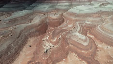 Aerial-View-of-Woman-Running-Between-Bentonite-Hills,-Hanksville-Utah-USA,-Drone-Shot