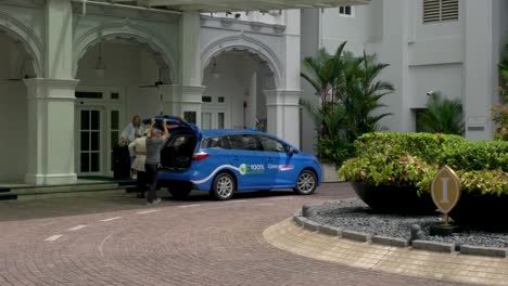 Conductor-De-Taxi-Y-Conserje-Ayudando-A-Los-Huéspedes-Del-Hotel-A-Cargar-El-Equipaje-En-El-Taxi-En-El-Intercontinental-Singapur