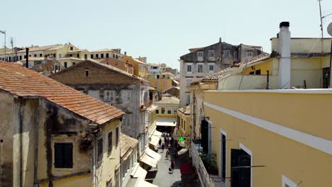 Calle-Del-Casco-Antiguo-De-Corfú-Con-Una-Farmacia,-Disparo-De-Drone,-Grecia