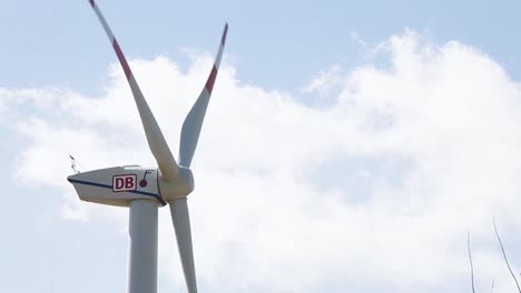 Primer-Plano-De-Una-Turbina-Eólica-De-Marca-Db-Contra-Un-Cielo-Nublado,-Concepto-De-Energía-Verde