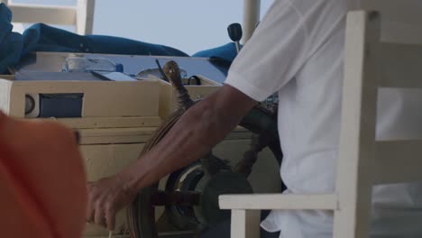 Back-View,-Helm-of-Wooden-Cruise-Boat-and-Captain,-Sailing-in-Sea-Water