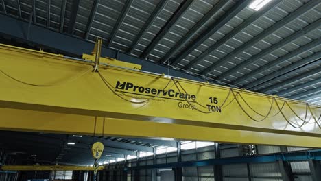 Aerial-jib-above-professional-yellow-overhead-bridge-crane-to-lift-heavy-objects-in-warehouse