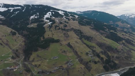 Saalbach-Hinterglemm-ski-resort-with-a-tilt-down-reveal-during-spring-thaw,-aerial-view