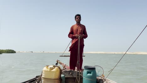 Pescador-Vestido-De-Rojo-Se-Encuentra,-En-Un-Barco-En-El-Río-Indo