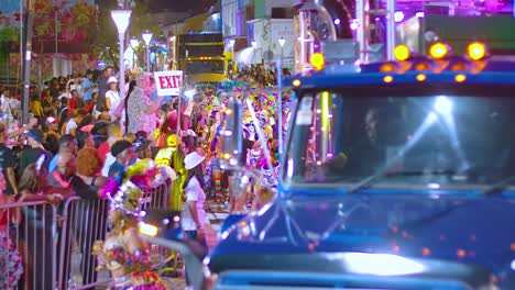 Flashing-lights-from-trucks-drive-through-streets-during-Carnival-parade-at-night