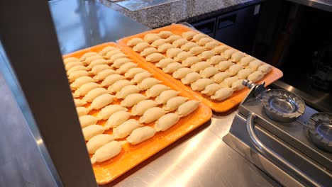 Two-large-trays-of-pierogi-on-the-kitchen-counter