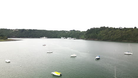 Forward-Tilt-of-Groups-of-Commercial-and-Derelict-Boats-Floating-on-Top-of-a-Calm-River