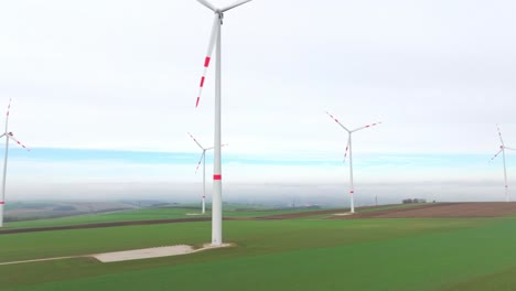 Windkraftanlage-Dreht-Sich-Hoch-Aufragend-Auf-Grünen-Ebenen
