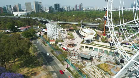Aerial-view-approaching-the-mechanical-games-and-rollercoaster-in-Aztlán-urban-park-Chapultepec,-Mexico-City