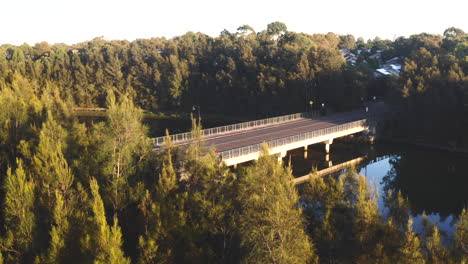 A-motorbike-drives-over-a-bridge-in-a-forested-suburb-in-Australia