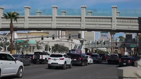 Tráfico-Diurno-Y-Puente-Peatonal-En-Una-Calle-Muy-Transitada-En-Las-Vegas,-Nevada.