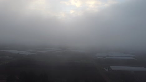 Luftvorwärtsflug-Durch-Graue-Wolken-über-Landwirtschaftlichen-Feldern-Und-Gewächshäusern-In-Der-Mexikanischen-Landschaft