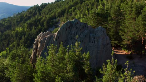 Dron-Orbitando-Alrededor-De-Una-Formación-Rocosa-Natural,-La-Roca-Del-águila-Orlovi-Skali,-Salpicada-De-Nichos-Trapezoidales-En-Forma-De-Colmena-En-La-Montaña-Ródope-En-Bulgaria