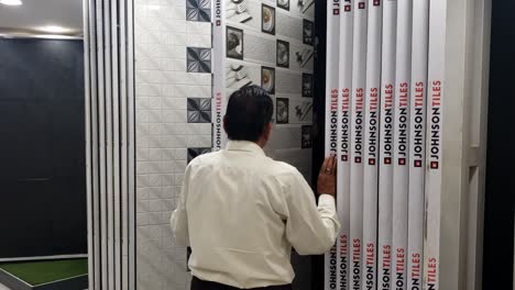 Shopkeeper-showing-various-tile-designs-to-customers-at-the-shop