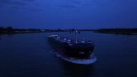 Tanker-Ship-Cruising-At-Oude-Maas-River-At-Dusk-In-The-Netherlands---Drone-Shot