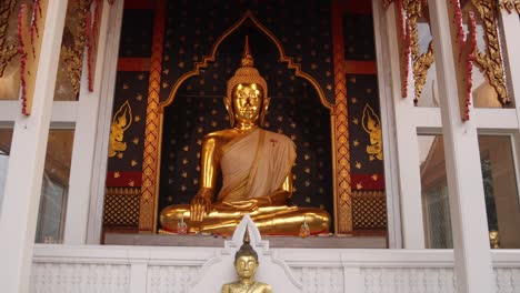 Estatua-Dorada-De-Buda-Meditando-Frente-A-Un-Templo-En-El-Casco-Antiguo-De-Rattanakosin-En-Bangkok,-Tailandia