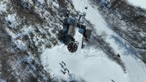 Top-down-shot-of-chair-lift-at-summit-of-mountain