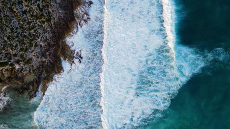 Vista-Aérea-Del-Rocío-Blanco-De-Olas-Del-Mar-Golpeando-Piedras