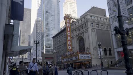 Daytime-view-of-Chicago-Theater-marquee-with-pedestrians-and-traffic,-downtown-urban-scene,-slight-overcast-sky