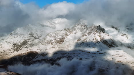 Erster-Frischer-Schneefall,-Der-Am-Späten-Nachmittag-Aufwirbelt,-Matterhorn-Landschaft,-Zermatt-Gletschergipfel,-Luftbilddrohne,-Herbst,-Schweizer-Alpen,-Gipfelgipfel,-Gornergratbahn,-Schweiz,-Rechte-Kreisbewegung