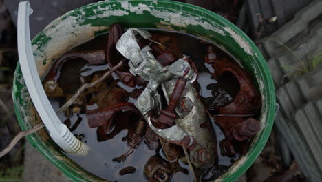 Bucket-of-rusty-metal-screws-and-plastic-in-water