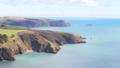 Scenic-telephoto-aerial-view-up-South-Devon-coastline,-UK