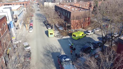 Approaching-drone-shot-showing-emergency-responders-helping-some-of-the-fire-victims-in-a-old-buiding-in-the-neighborhood-of-Montreal,-Canada