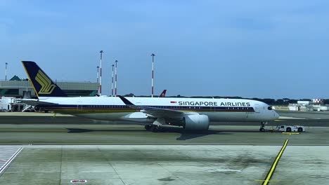 Singapore-Airlines-aircraft-pulled-by-pushback-truck-on-airport-tarmac