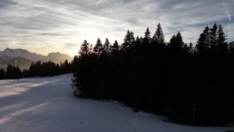 Alpine-sunset-lens-flare-over-Amden's-serene-landscape,-Switzerland---aerial