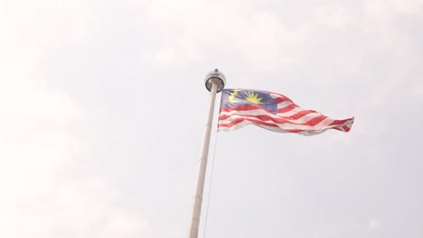 Bandera-De-Malasia-Ondeando-Al-Viento-Sobre-La-Ciudad-Capital,-Kuala-Lumpur,-Malasia