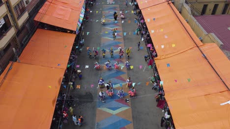 Festive-dancers-in-Carnival-parade-in-Oruro-Bolivia,-high-angle-view