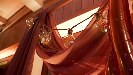 Girlande-Aus-Dekorativen-Glühbirnen,-Die-An-Einer-Rosa-Dekorativen-Wand-Hängen
