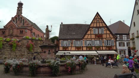Eguisheim's-Saint-Léon-square-is-dominated-by-the-castle-and-in-the-middle-stands-a-fountain-with-a-statue-of-St