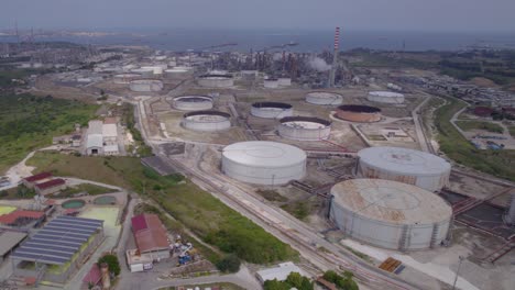 Aerial-trucking-shot-of-the-old-empty-fuel-storage-facility-in-Catania,-Sicily,-Italy