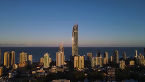 Ein-Hoch-Aufragender-Wolkenkratzer-Leuchtet-Im-Sonnenuntergang-Am-Nachmittag-Und-Erhebt-Sich-über-Einer-Küstenstadtlandschaft