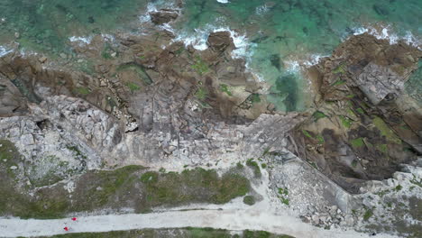 Overhead-Aerial-View-of-Rocky-Seaside-and-Body-of-Water
