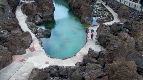 Tourists-At-Piscinas-Naturais-do-Aquário-Swimming-Basin-in-Porto-Moniz,-Madeira-Islands-In-Portugal