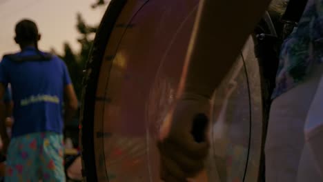 Closeup-of-drummer-hitting-on-tenor-drum-during-Carnival-parade-wearing-floral-patterns-at-sunset