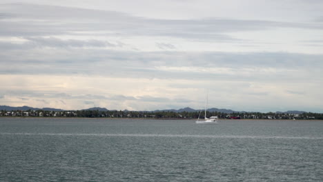 Boat-ride-Tourism-Fiji-Nada-Suva-Garden-Island-Coral-Coast-Taveuni-follow-sailboat-morning-mountain-peaks-tropical-island-palm-coconut-tree-cloudy-blue-sky-Pacific-Ocean-calm-bay-follow-motion