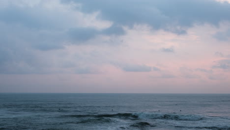 Surfer-Am-Tropischen-Strand-Mit-Vögeln-Fliegen-Bei-Sonnenuntergang-In-Bali,-Indonesien