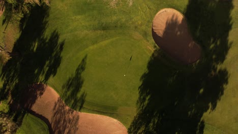 Aesthetic-rotating-aerial-shot-of-a-golf-green-and-bunkers