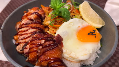 Delicious-Thai-crispy-fried-duck-with-fried-egg,-vegetables-and-white-rice,-spicy-Asian-food,-4K-shot