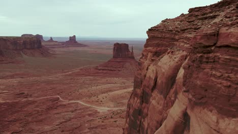 A-spectacular-4K-drone-shot-of-the-towering-Mittens-and-Merrick-Buttes-in-the-Oljato-Monument-Valley,-part-of-the-Navajo-Nation-and-located-on-the-Arizona-side-of-the-Arizona-Utah-border,-USA