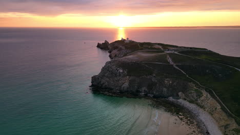Forward-Linear-Aerial-View-of-Sunset-Beach-with-Rocky-Cliffs