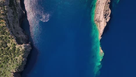 Amazing-crystal-clear-water-and-cliff-top-down-drone-shot